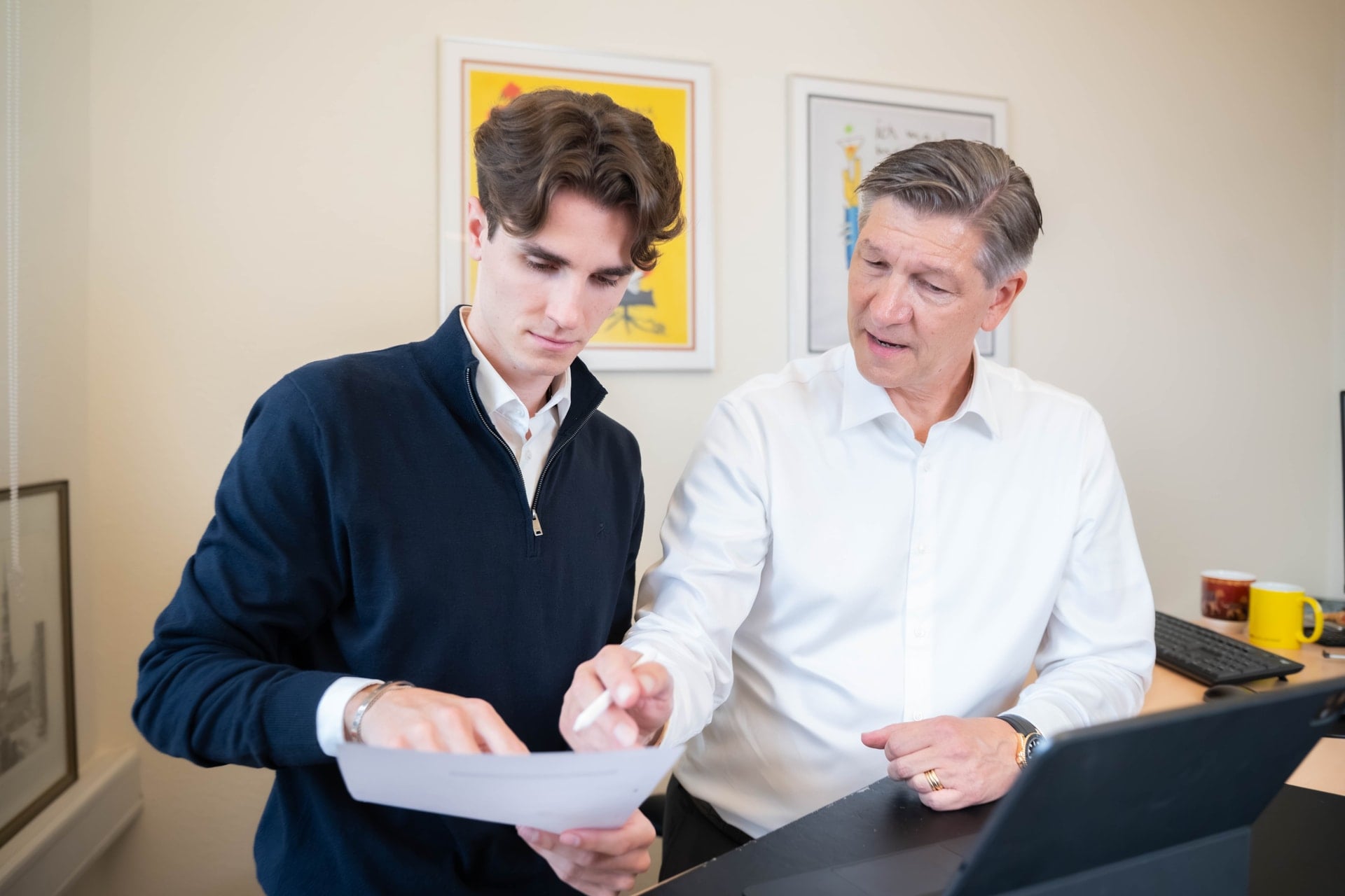 Zwei Kollegen besprechen ein Dokument am Schreibtisch